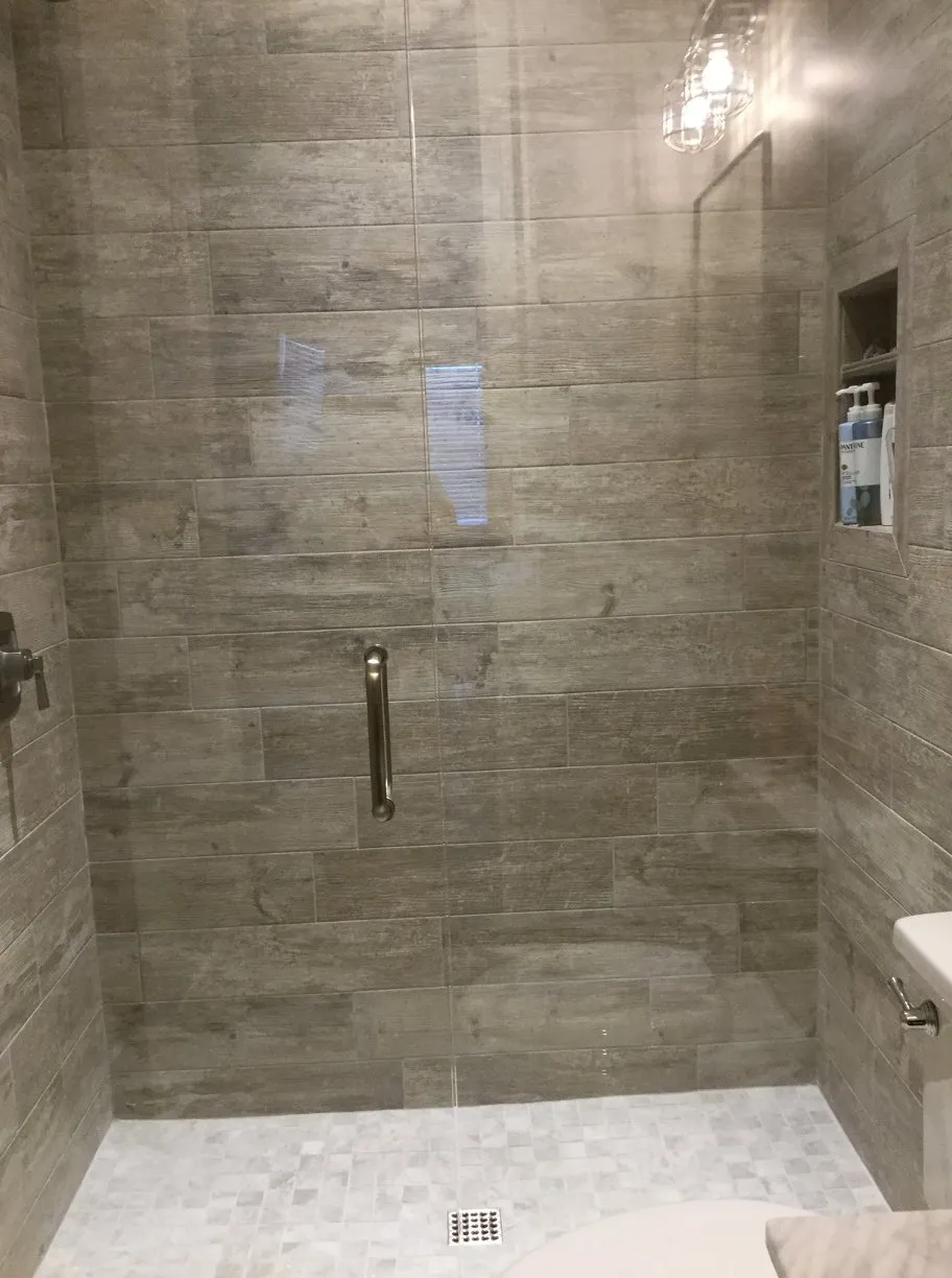 Walk-in tile shower with stone bench seat